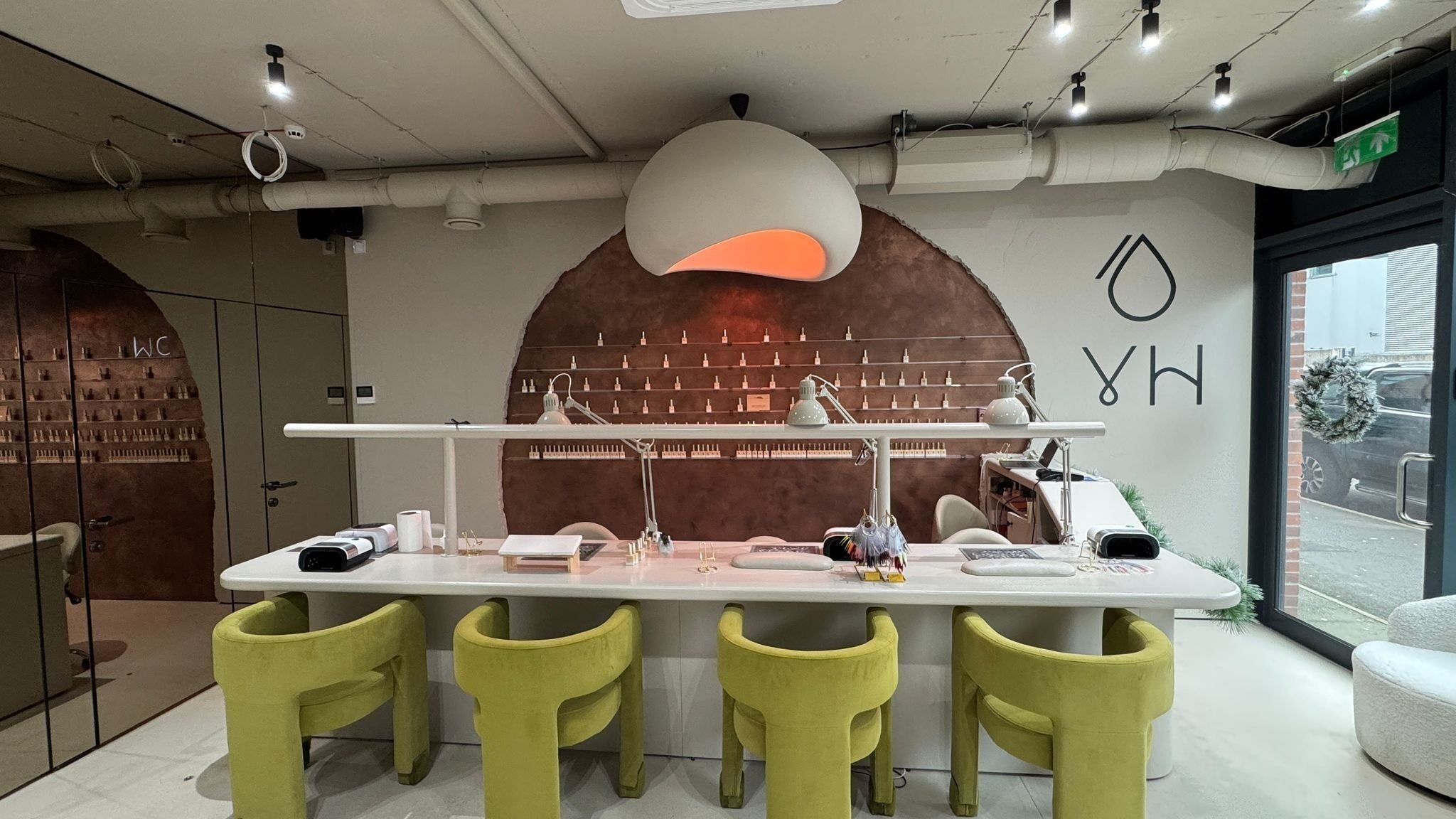 Yulia Hamilton nails & beauty in Manchester, England, GB features a stylish, modern nail bar with green chairs.