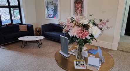 Chantara Thai Massage reception in Norwich, England, GB, features elegant seating and vibrant floral decor.