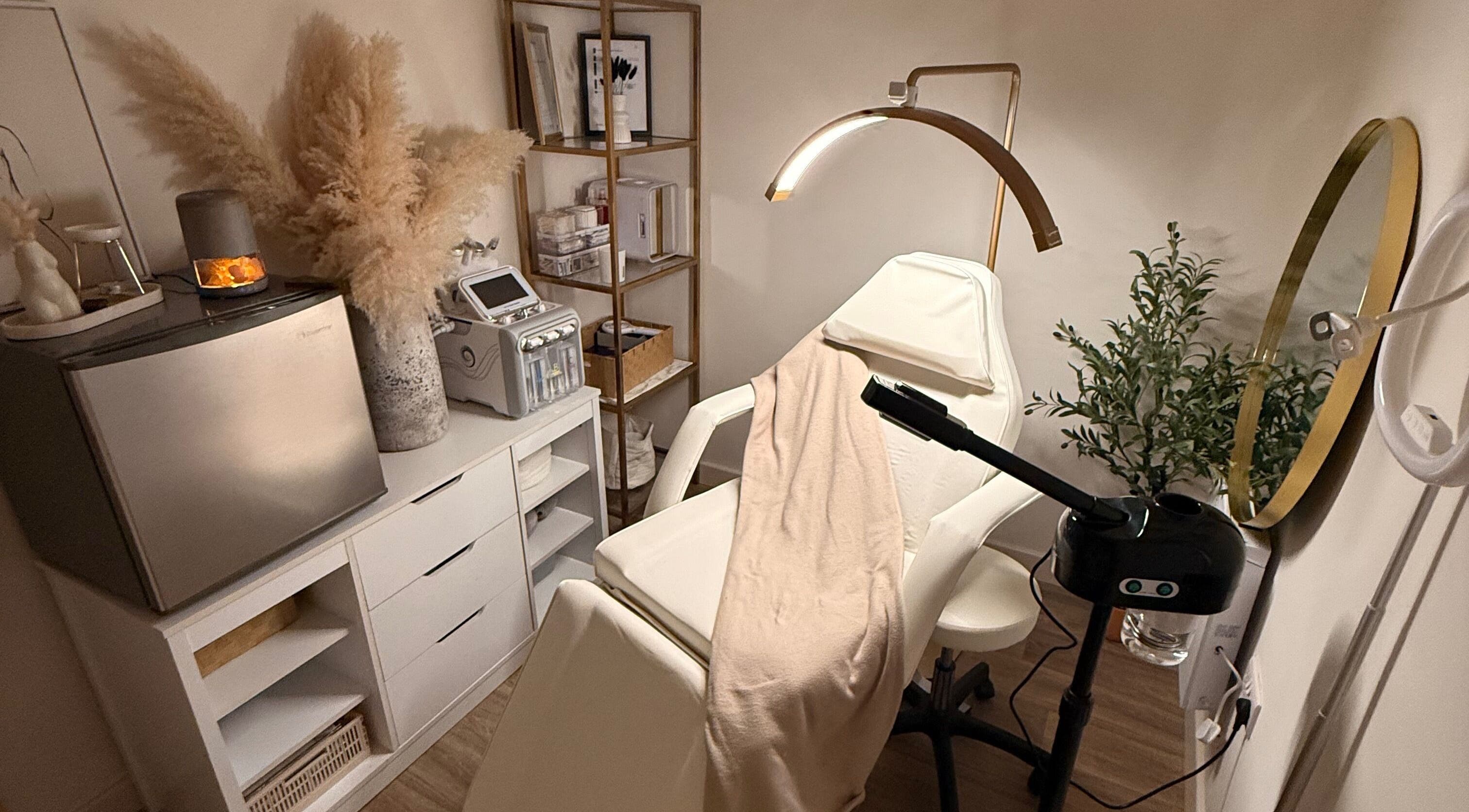 Cozy treatment room at Alla Skin & Aesthetics in Norwich, England, GB with chair, plants, and equipment.