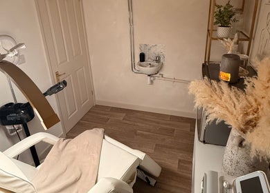 Cozy treatment room at Alla Skin & Aesthetics in Norwich, England, GB with reclining chair and warm decor.