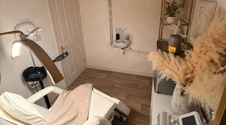 Cozy treatment room at Alla Skin & Aesthetics in Norwich, England, GB with reclining chair and warm decor.
