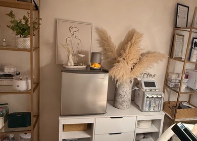 Cozy skincare setup at Alla Skin & Aesthetics, Norwich, England, GB. Shelves with beauty products and stylish decor.