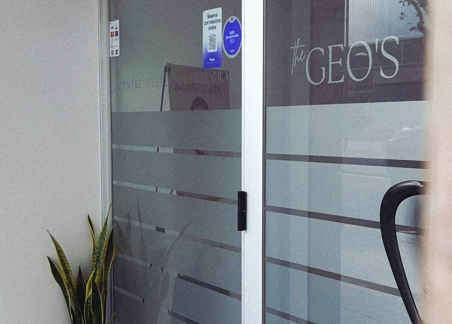 Puerta de entrada de GEO'S | Estética Integral en Reus, Catalunya, ES, con diseño moderno y planta decorativa.