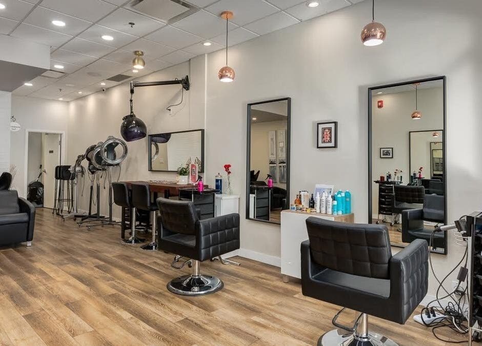 Spacious interior of London Hair Salon Macleod Trail, Calgary, Alberta, CA with modern chairs and mirrors.