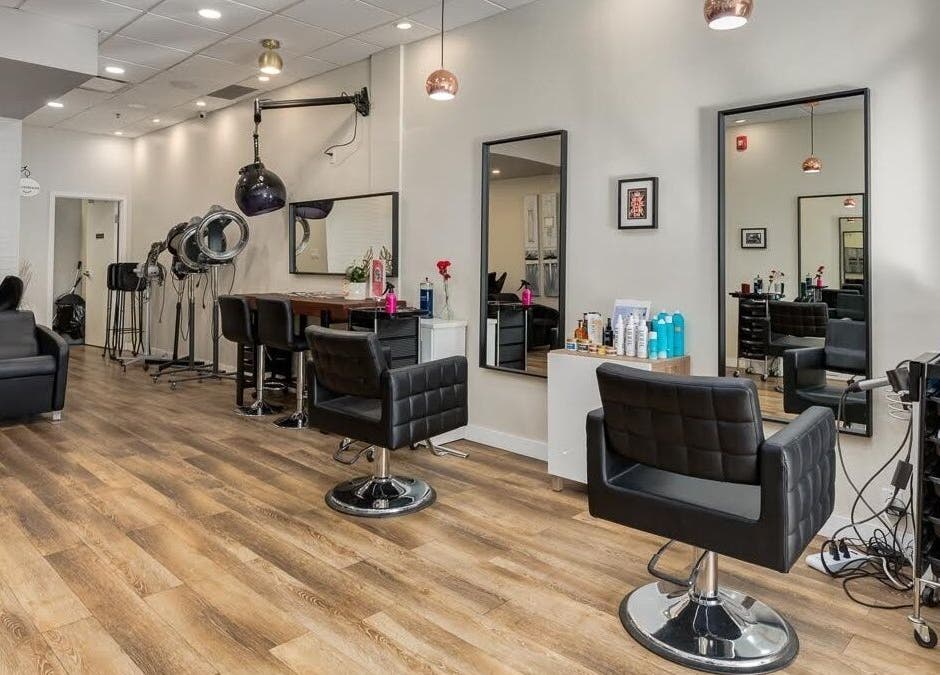 Modern interior of London Hair Salon Macleod Trail in Calgary, Alberta, CA featuring stylish black chairs and mirrors.