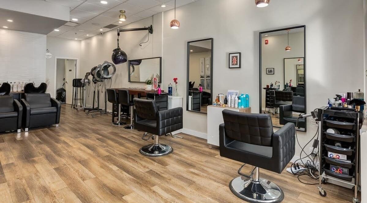 Modern interior of London Hair Salon Macleod Trail in Calgary, Alberta, CA featuring stylish black chairs and mirrors.