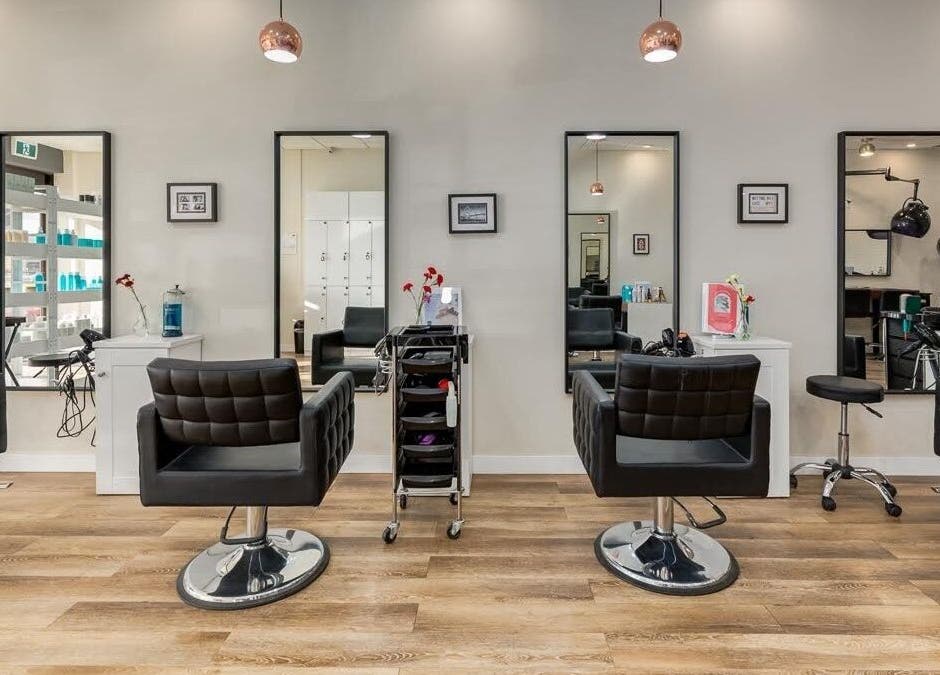 Modern interior of London Hair Salon Macleod Trail in Calgary, Alberta, CA with stylish black chairs and mirrors.