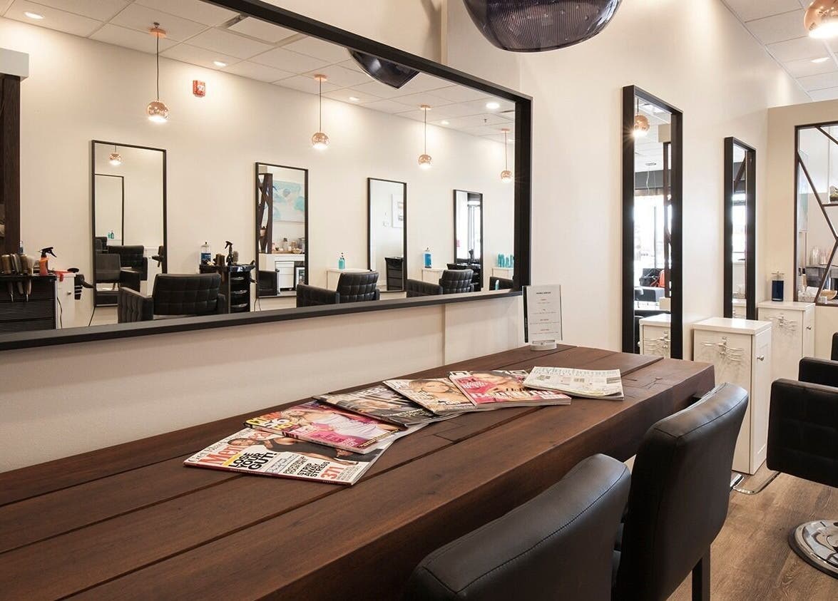 Modern interior of London Hair Salon Macleod Trail in Calgary, Alberta, CA with stylish black chairs and mirrors.