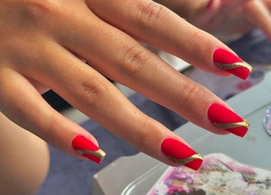 Stylish red and gold nails at Khoi Pond Nails, Topsfield, Massachusetts, US.
