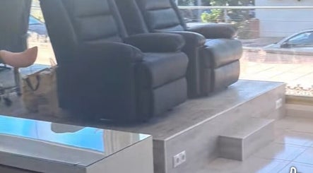 Comfortable black recliners at The Hair Fairy, Estepona, Andalucía, ES, offering relaxation and style.