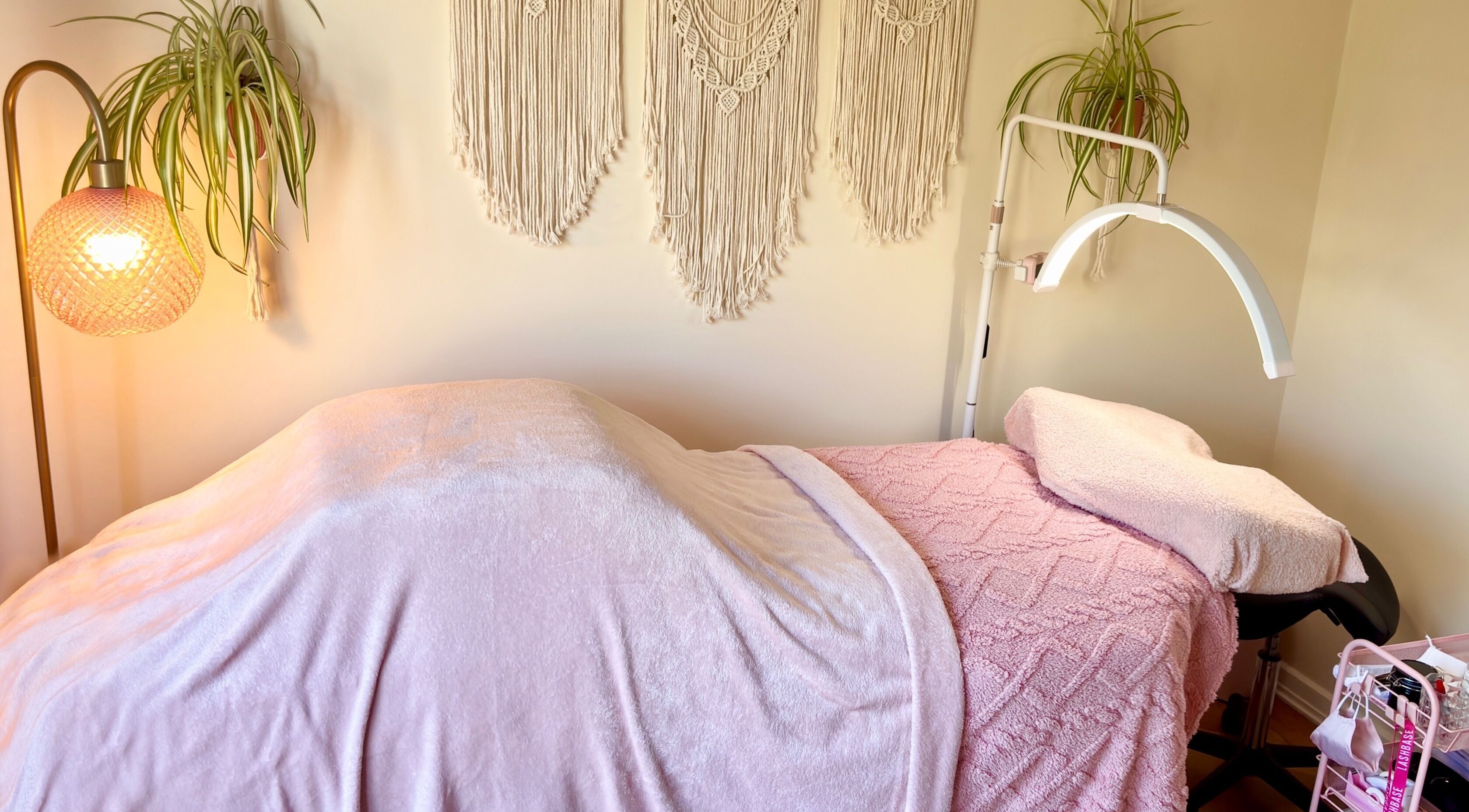Cozy treatment bed at Georgie’s Lash Lounge in Chelmsford, England, GB, with soft lighting and decor.