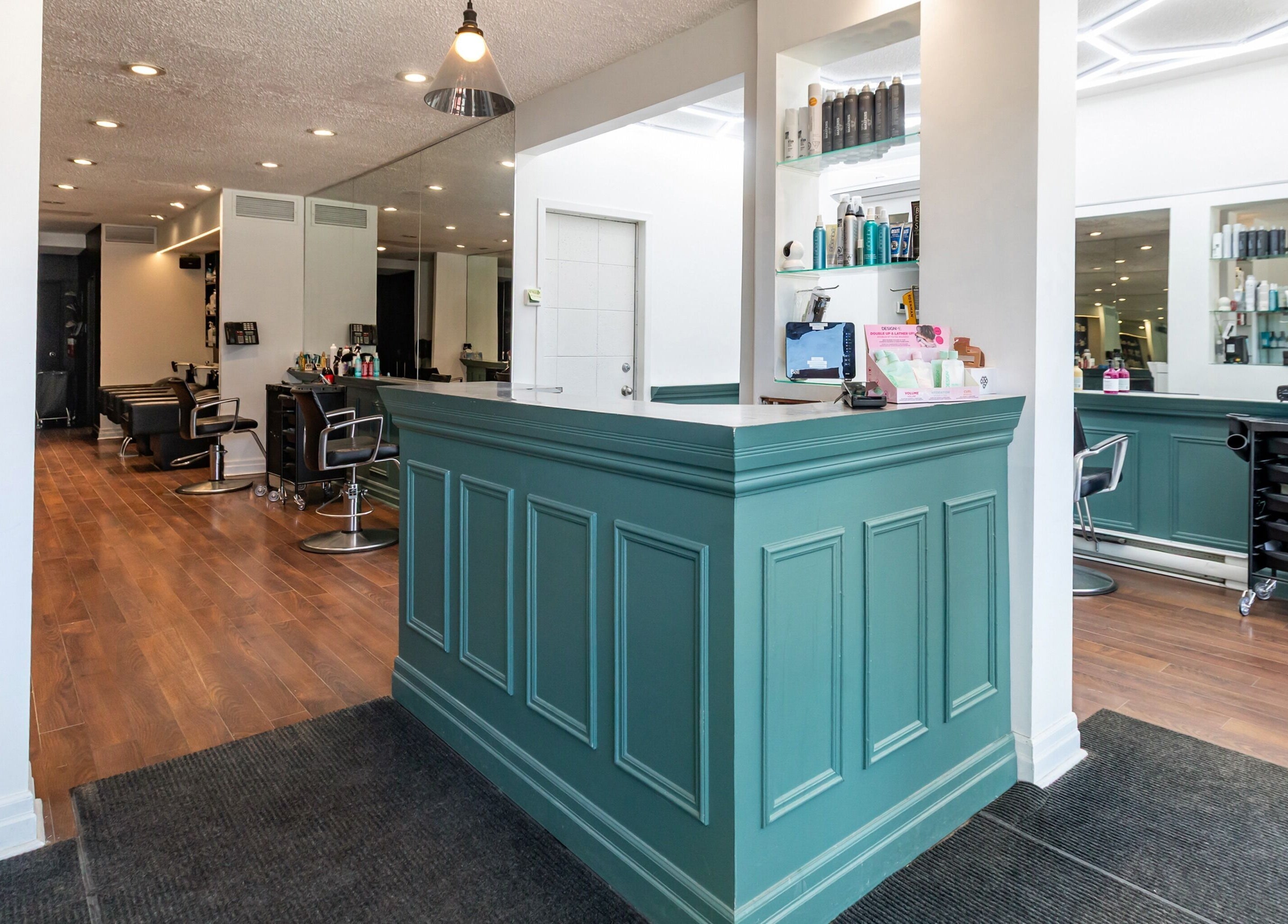 Intérieur moderne du Salon Pierre Alexandre à Montréal, Québec, CA avec planchers en bois et comptoir vert.