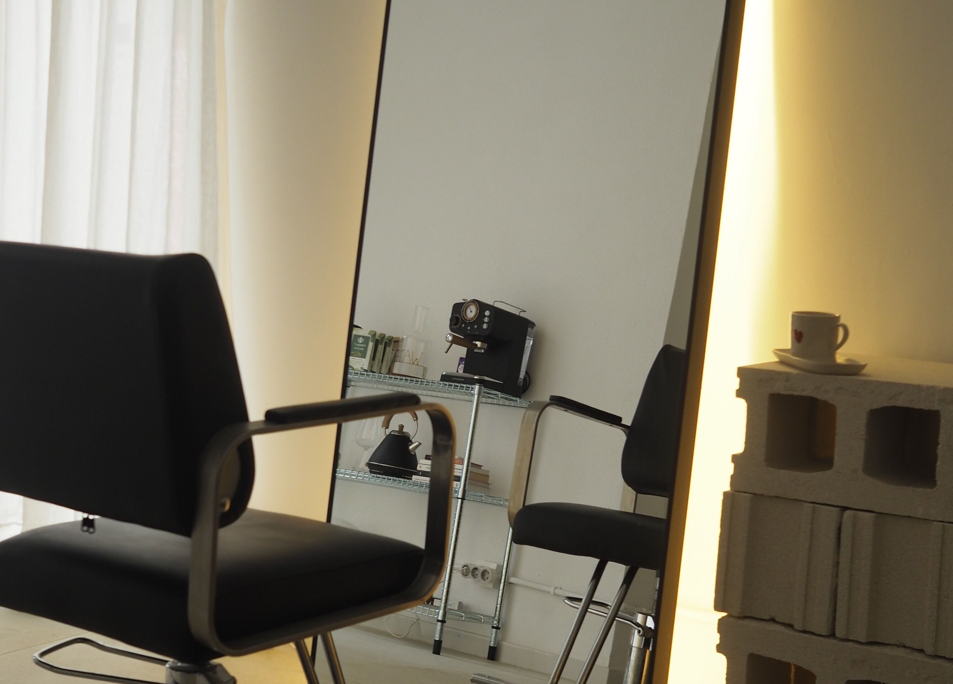 Silla de salón frente a un espejo iluminado en Ginga Estudio By Fefis, Barcelona, Catalunya, ES.