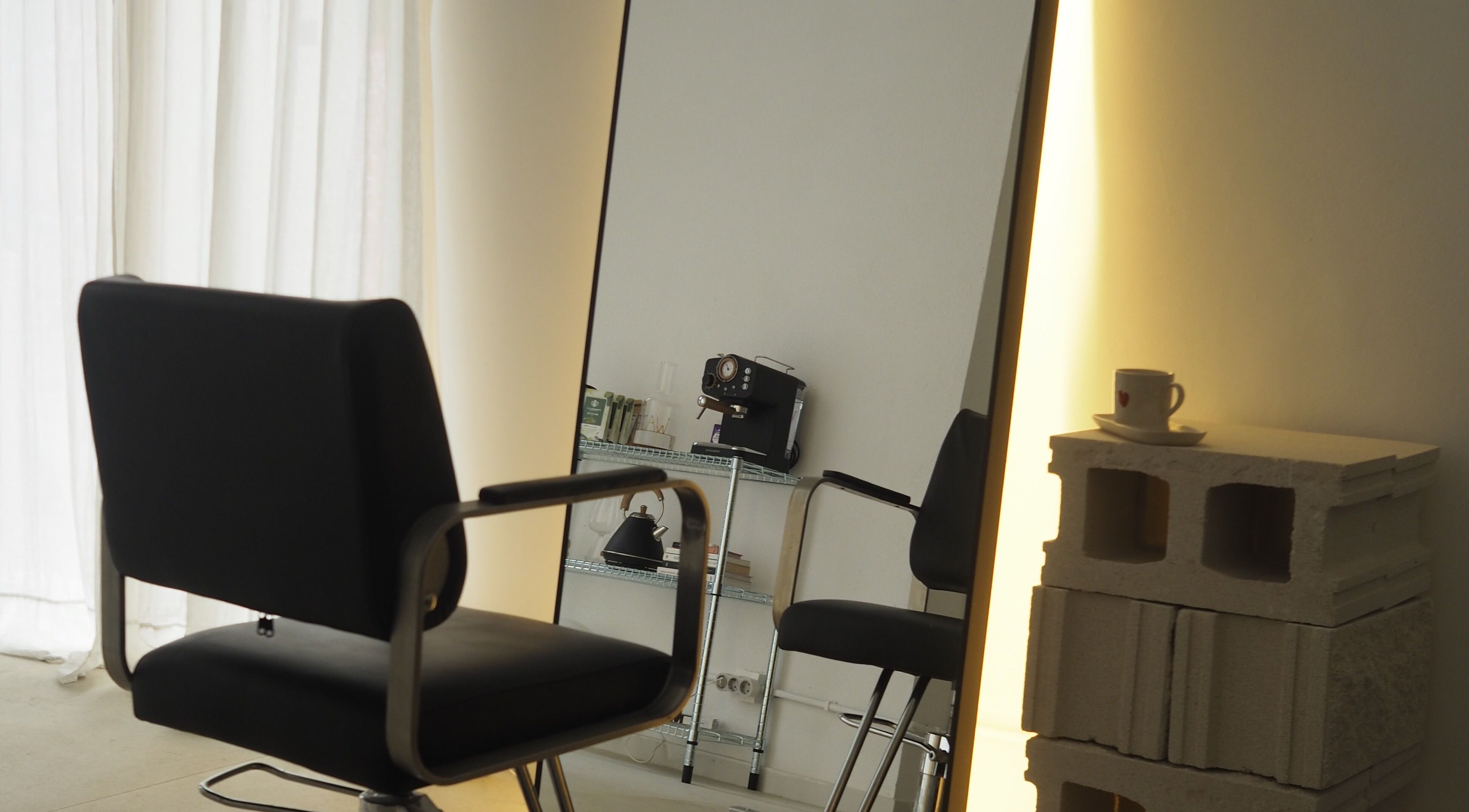 Silla de salón frente a un espejo iluminado en Ginga Estudio By Fefis, Barcelona, Catalunya, ES.