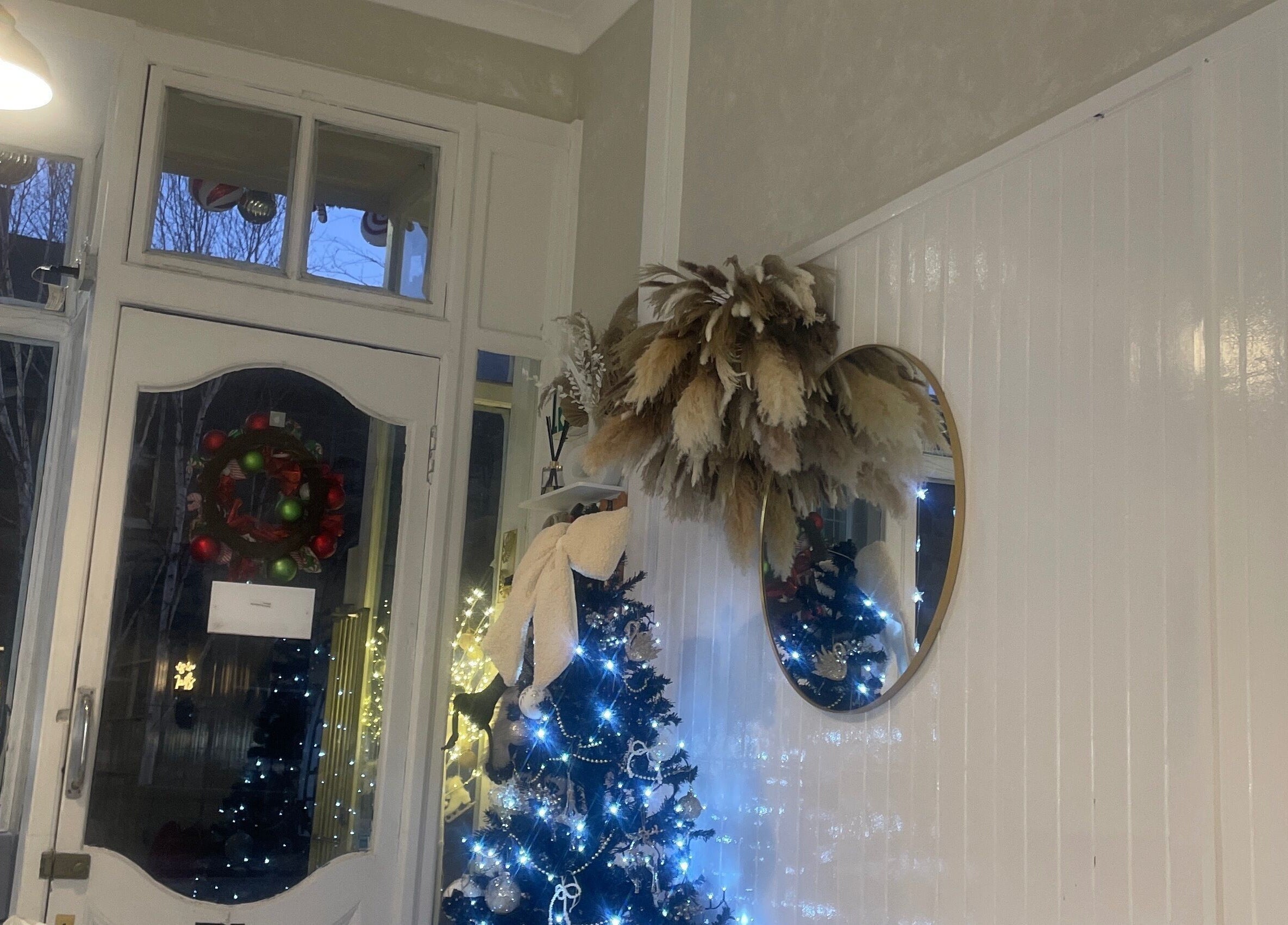 Holiday decor in Got2 Blashed, Edinburgh, Scotland, GB with wreath and lit tree reflecting tranquility.