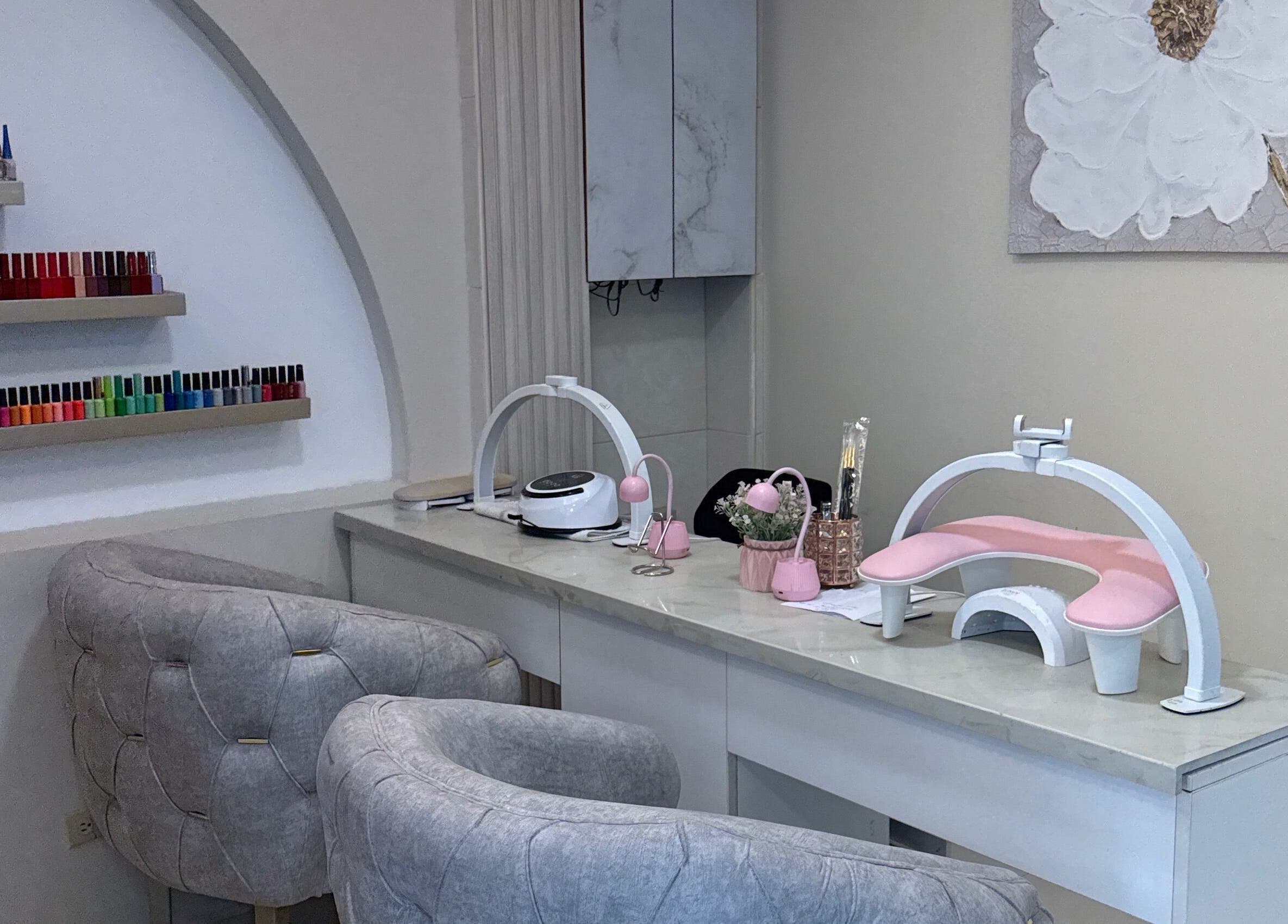 Estación de manicura elegante en Rose Room, Guayaquil, Guayas, EC, con sillas cómodas y esmaltes organizados.