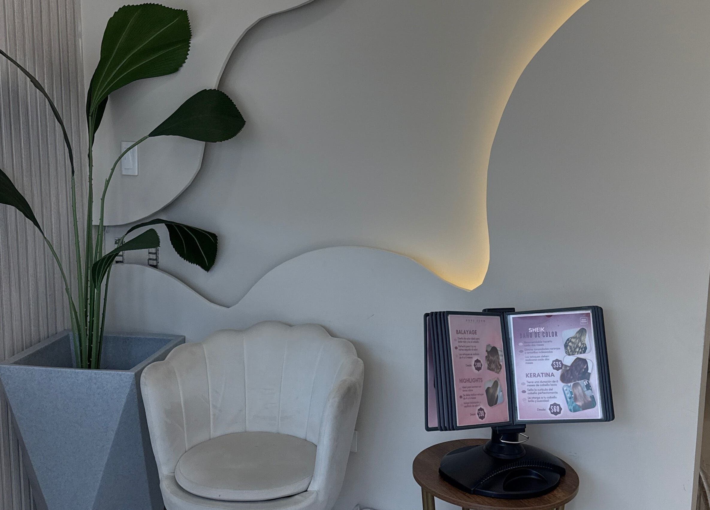 Recepción elegante con silla blanca y planta en Rose Room, Guayaquil, Guayas, EC.