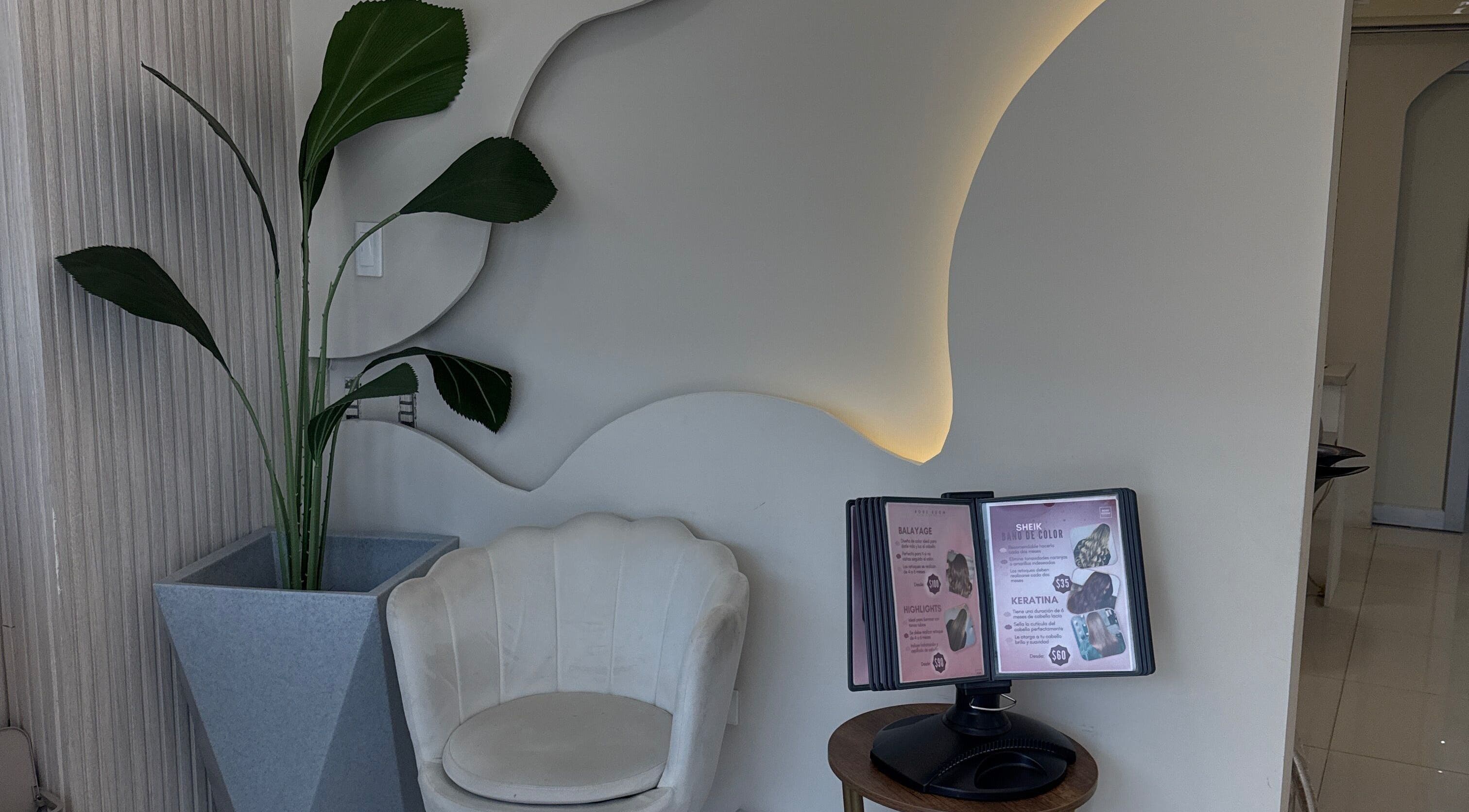 Recepción elegante con silla blanca y planta en Rose Room, Guayaquil, Guayas, EC.