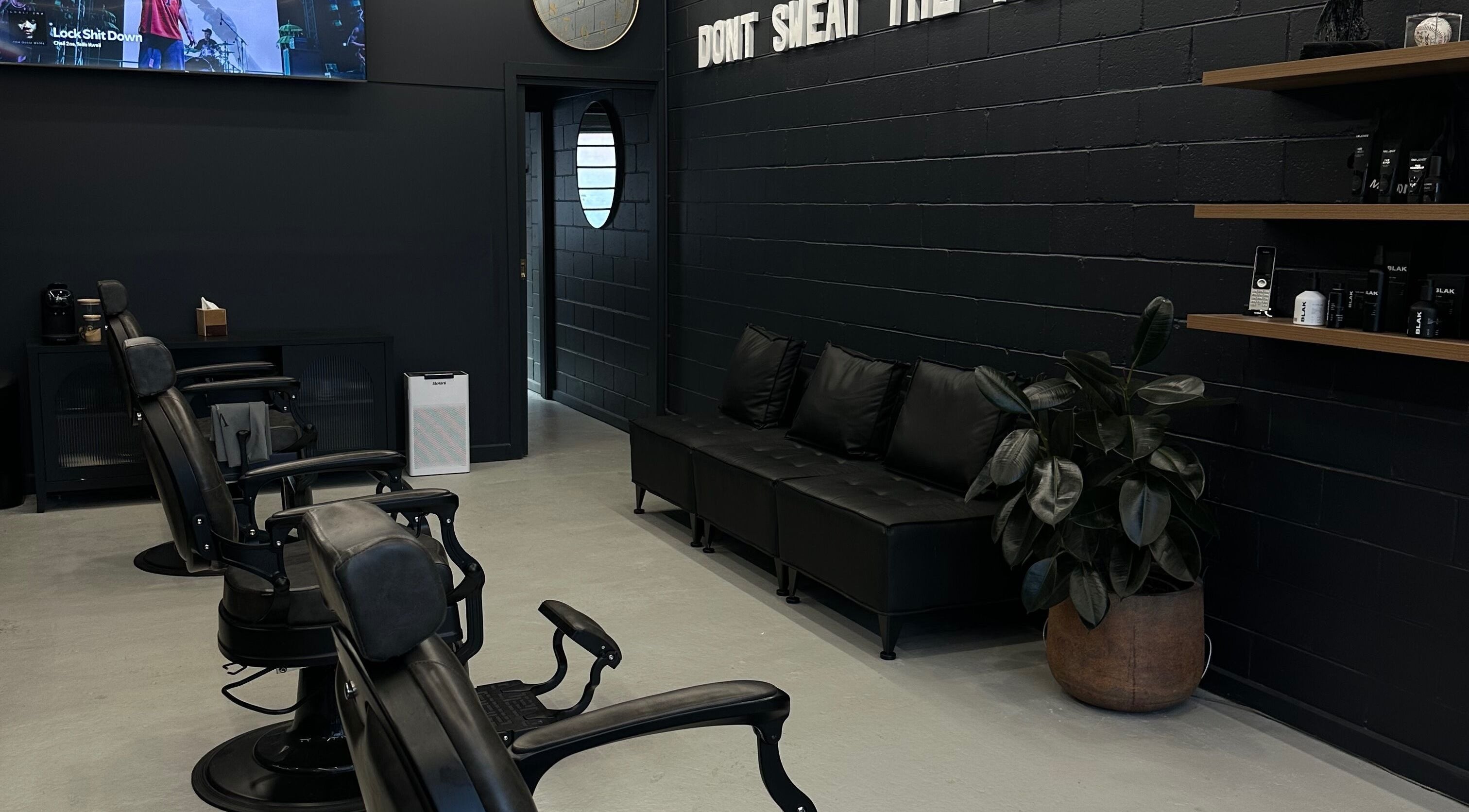 Modern interior of Virtuoso Black in Melbourne, Victoria, AU with sleek barber chairs and elegant decor.