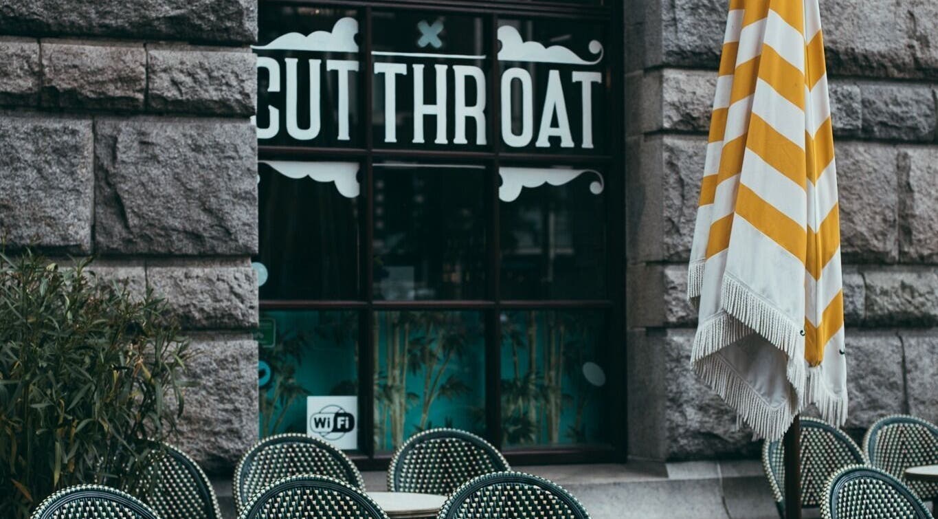 Outdoor seating at Cut Throat - Beursplein, Amsterdam, Noord-Holland, NL with visible signage.