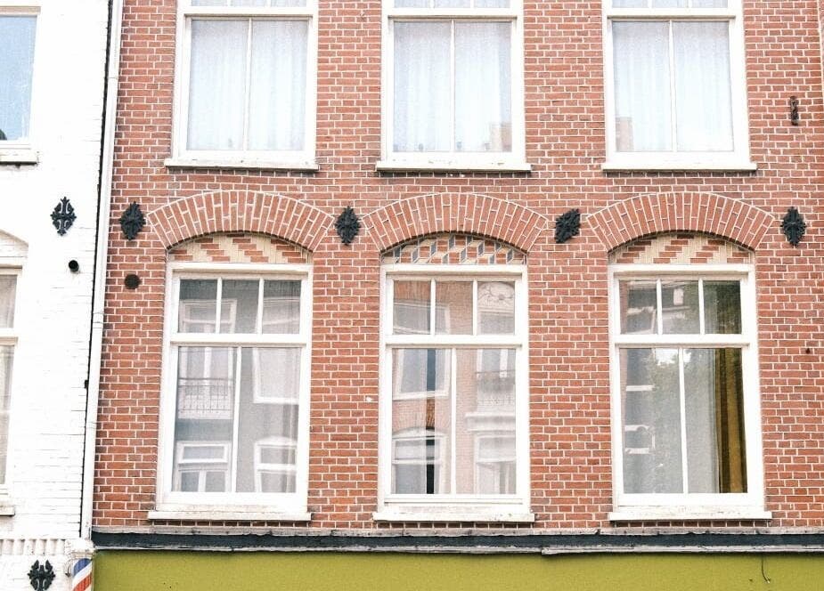 Brick facade of Cut Throat - West in Amsterdam, Noord-Holland, NL, showcasing elegant vintage architecture.