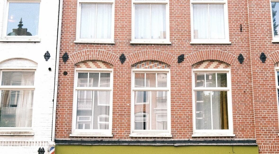 Brick facade of Cut Throat - West in Amsterdam, Noord-Holland, NL, showcasing elegant vintage architecture.