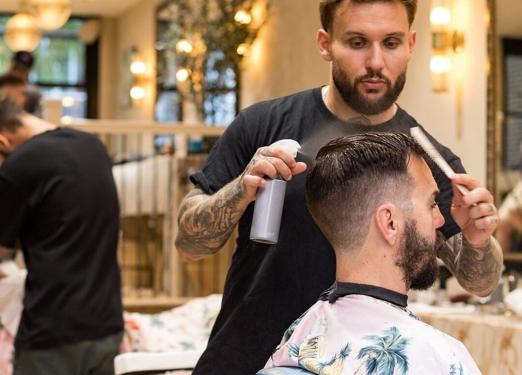 Professional stylist at Cut Throat - De Pijp, Amsterdam, Noord-Holland, NL, crafting a stylish haircut.