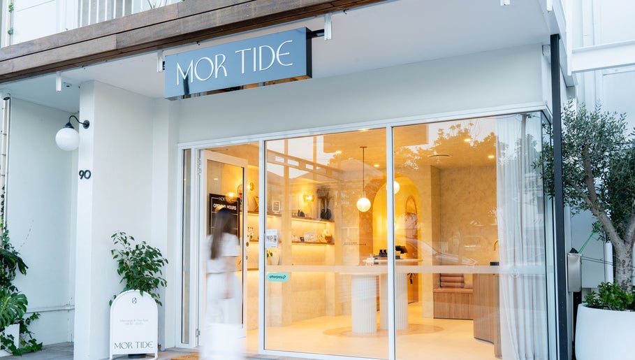 Exterior view of Mor Tide Day Spa, Fortitude Valley, Queensland with elegant glass entrance and lush greenery.