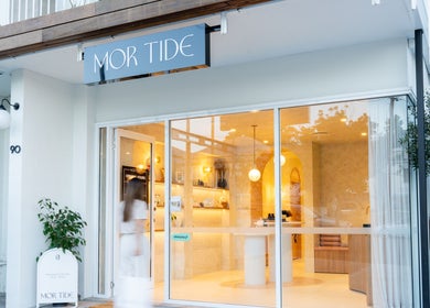 Exterior view of Mor Tide Day Spa, Fortitude Valley, Queensland with elegant glass entrance and lush greenery.
