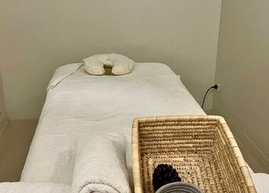 Relaxing massage room at Mor Tide Day Spa, Fortitude Valley, Queensland, AU. Cozy bed and basket in tranquil setting.