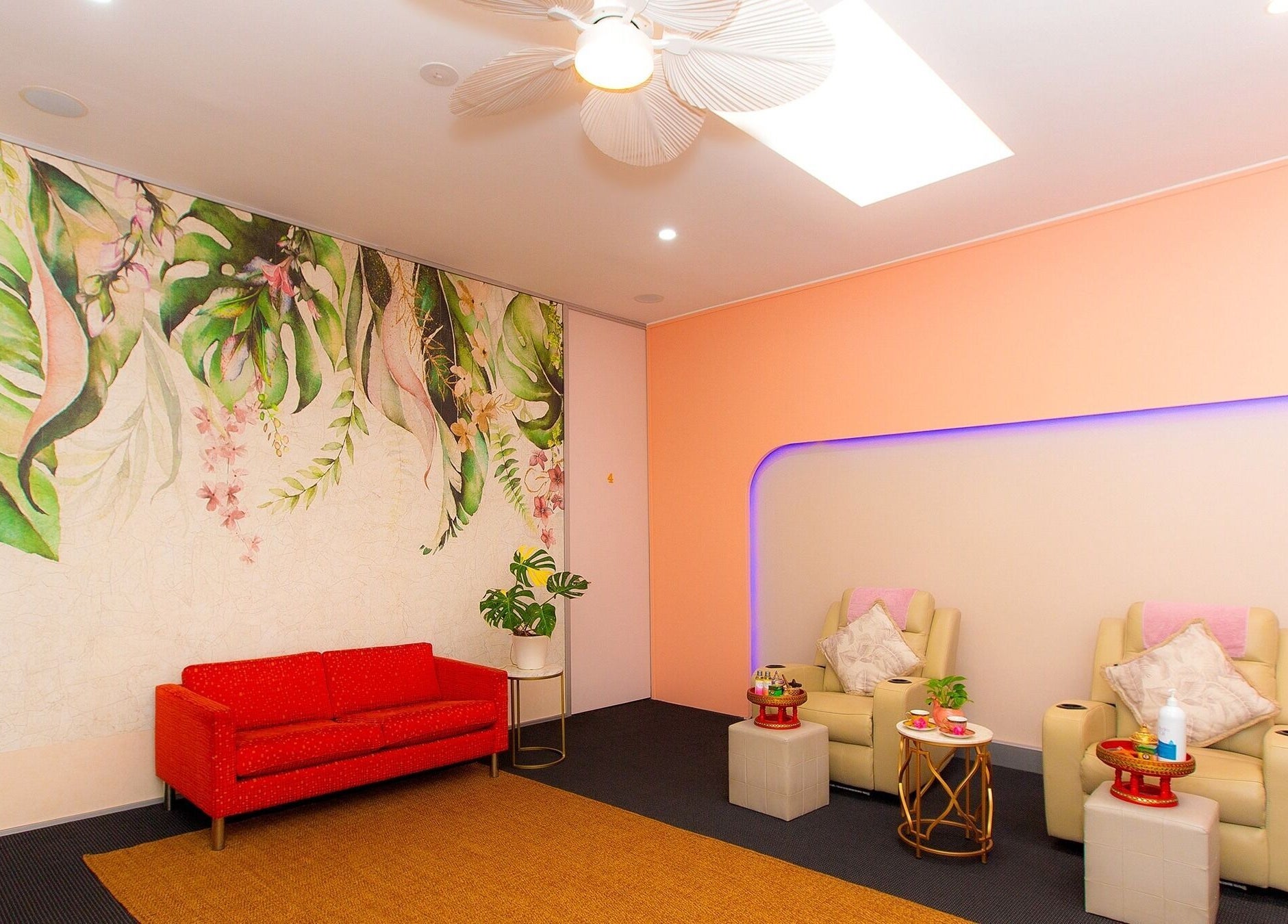 Relaxing seating area at Chat Thai Massage, Crows Nest, New South Wales with tropical wall art and cozy chairs.