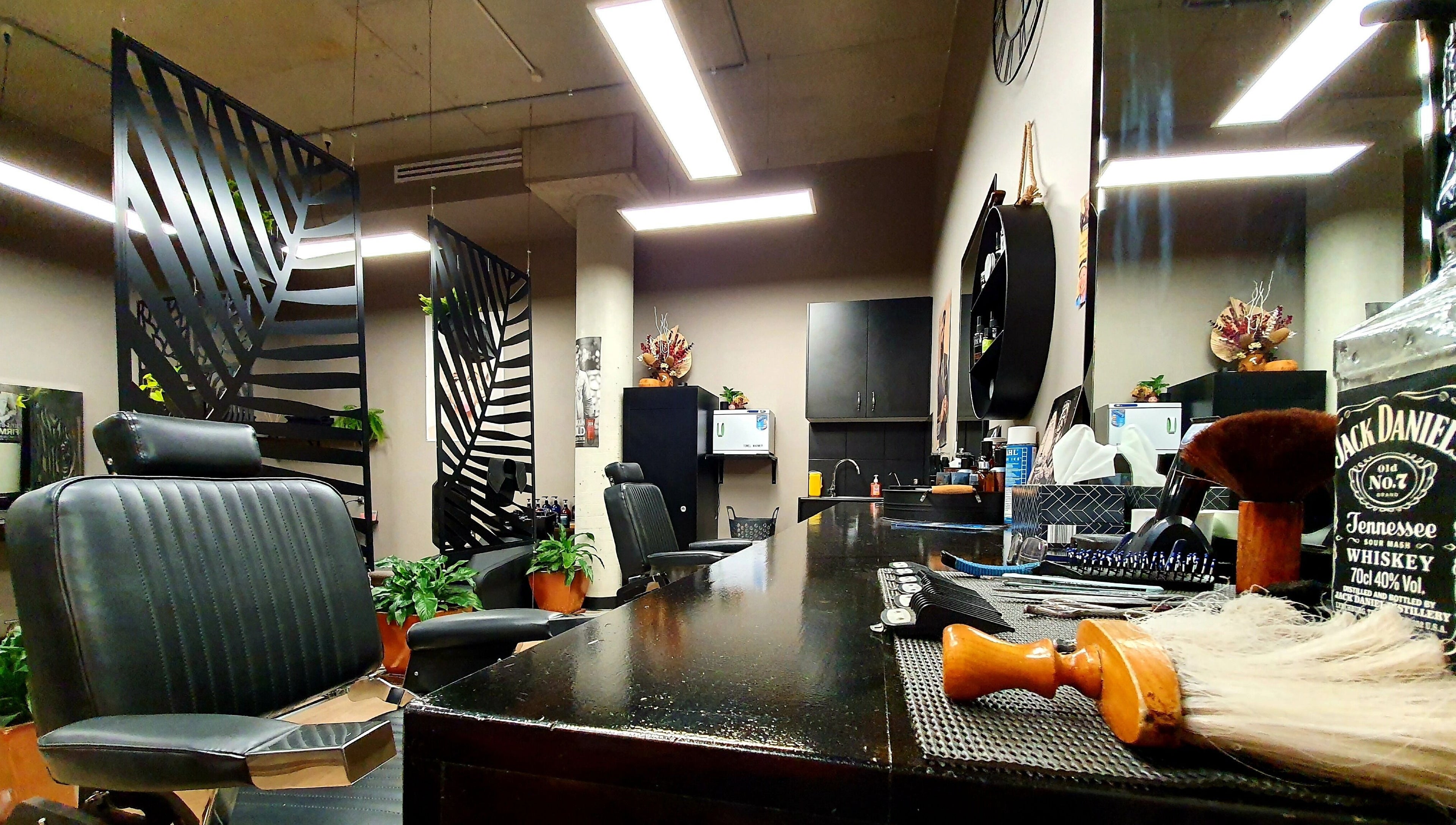 Modern interior of Thrones Barber and Stylists in Parkwood, Queensland, AU showcasing sleek chairs and decor.