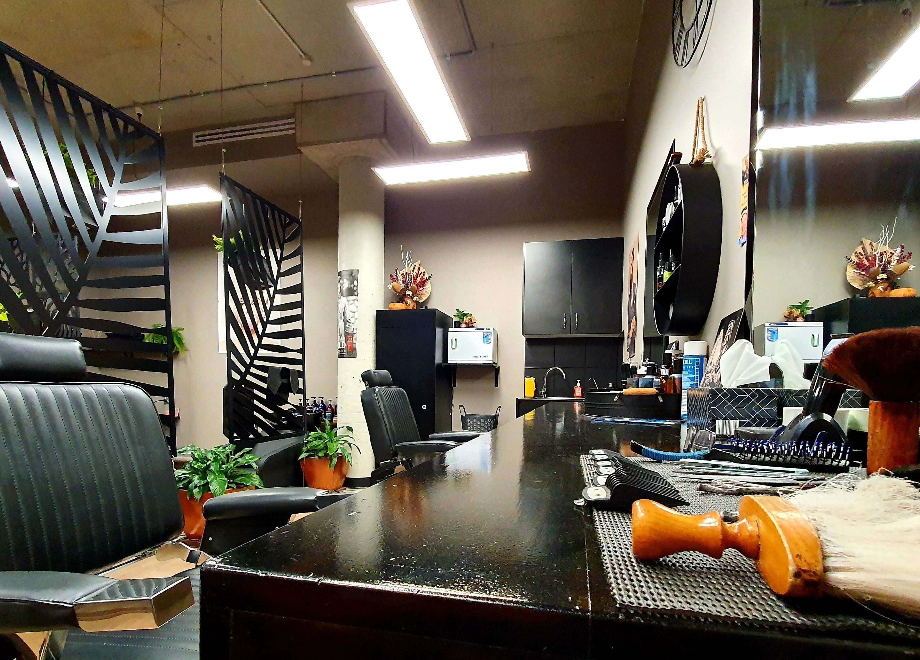 Modern interior of Thrones Barber and Stylists in Parkwood, Queensland, AU showcasing sleek chairs and decor.