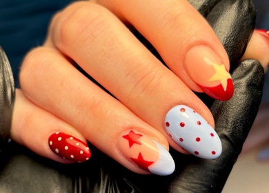 Creative starry nail art at The Brow & Nail Lounge, Worthing, England, GB. Vibrant red and polka dot design.