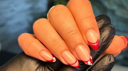 Close-up of manicured nails with red tips at The Brow & Nail Lounge, Worthing, England, GB.
