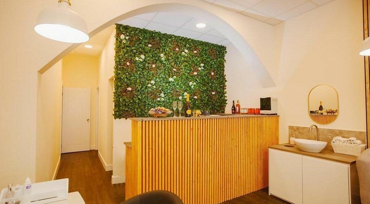 Inviting reception at D'lux Nails and Beauty Salon, London, England, GB, featuring a lush green wall decor.