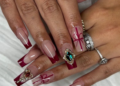 Red-tipped nails with jewel accents at Allure Nails, North Lakes, Queensland, AU.
