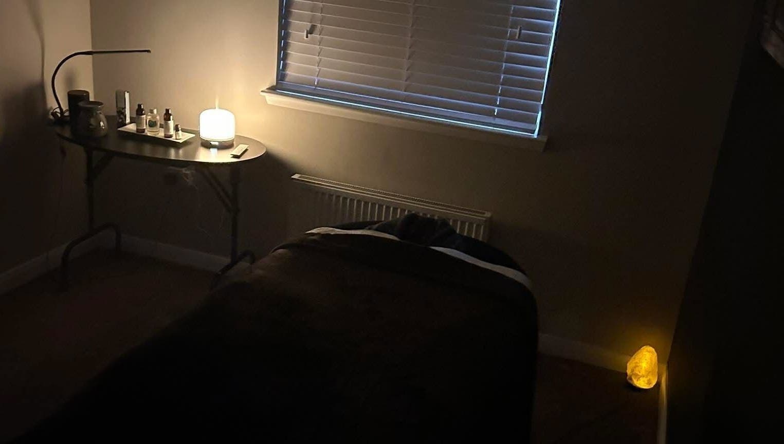 Relaxing room at Beauty By Dennon, West Calder, Scotland, GB, featuring a massage table and ambient lighting.