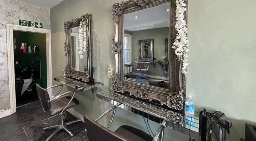 Chic styling area at Hair Station 26, Rainham, England, GB with ornate mirrors and modern chairs.