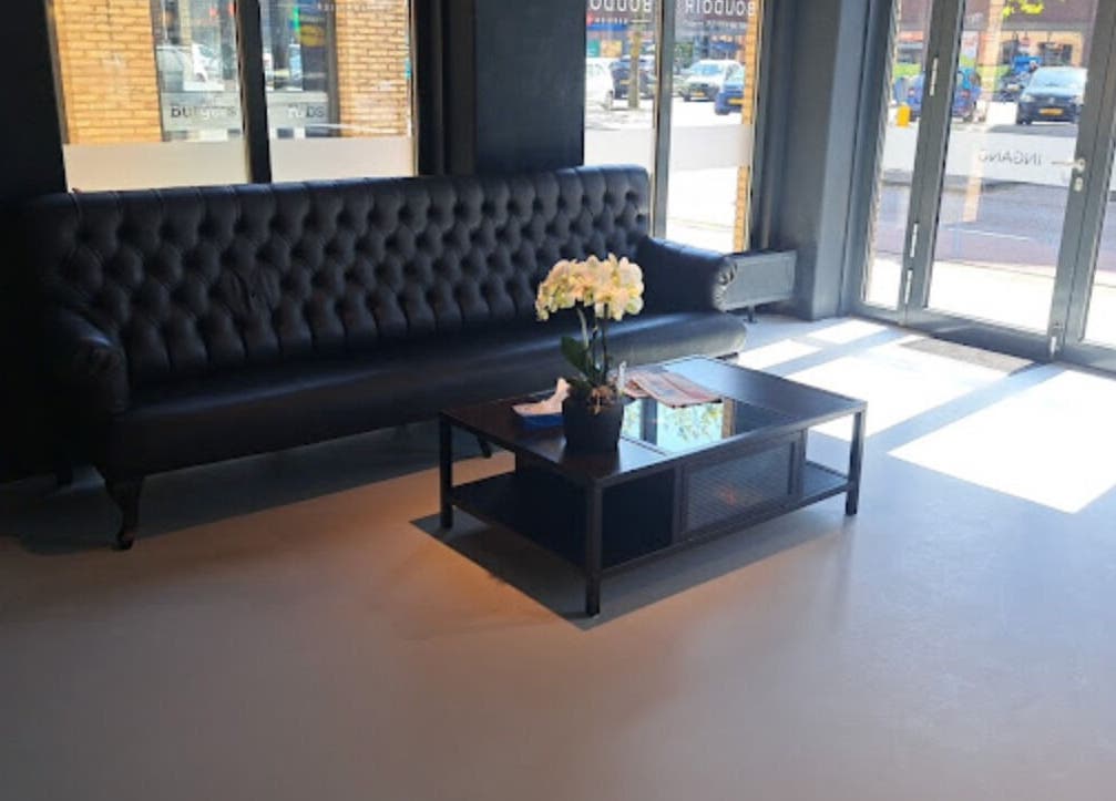 Stijlvolle lounge bij Boudoir Barbier in Almelo, Overijssel, NL met zwarte bank en salontafel.
