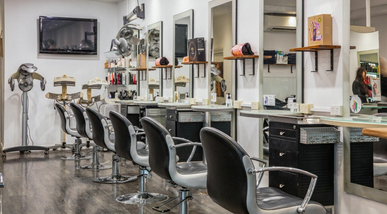 Modern salon interior at Maddness Hair Design in Bundoora, Victoria, AU features stylish seating and mirrors.