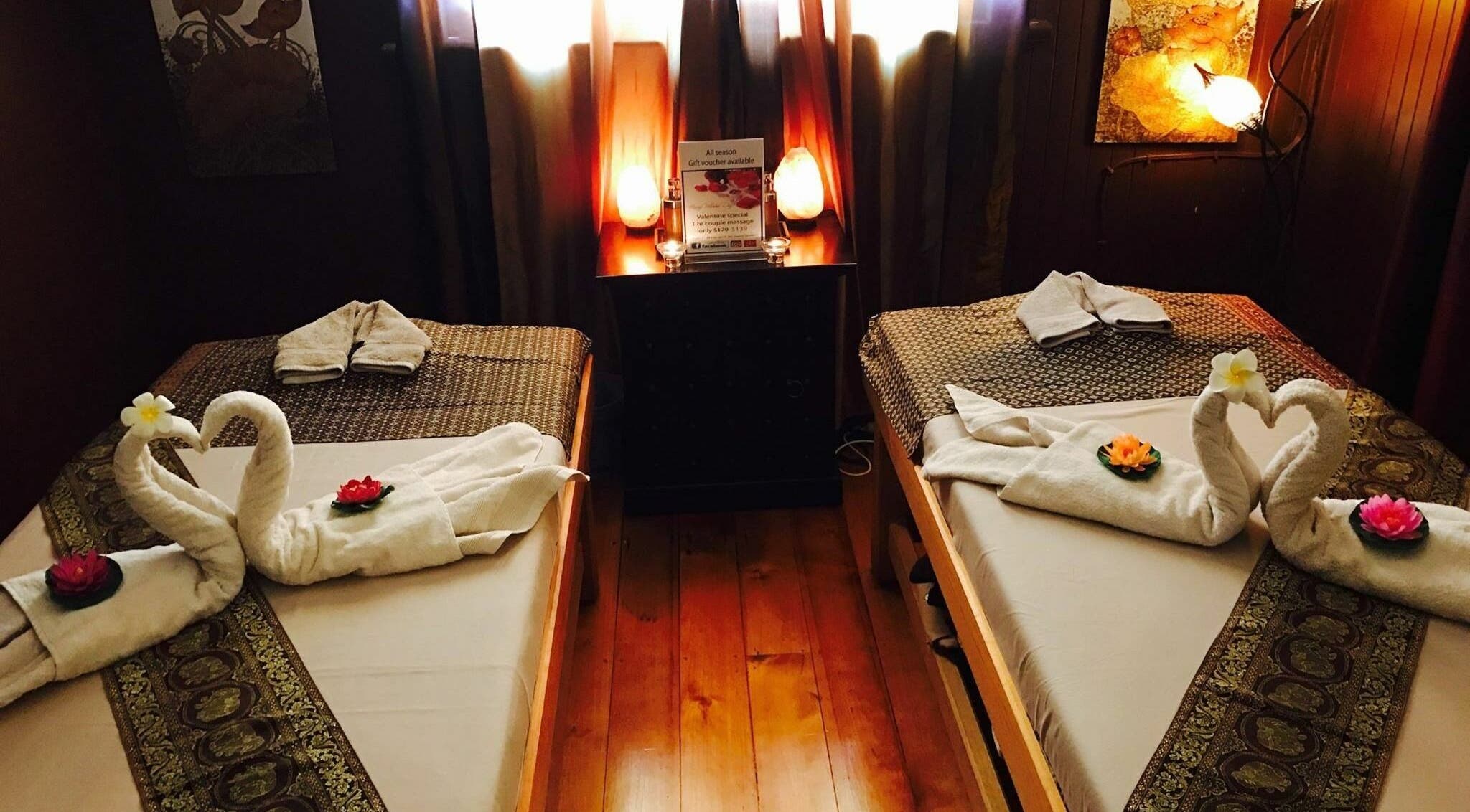 Luxurious massage tables at Siri Thai Massage, West End, Queensland, AU, adorned with towel swans and flowers.
