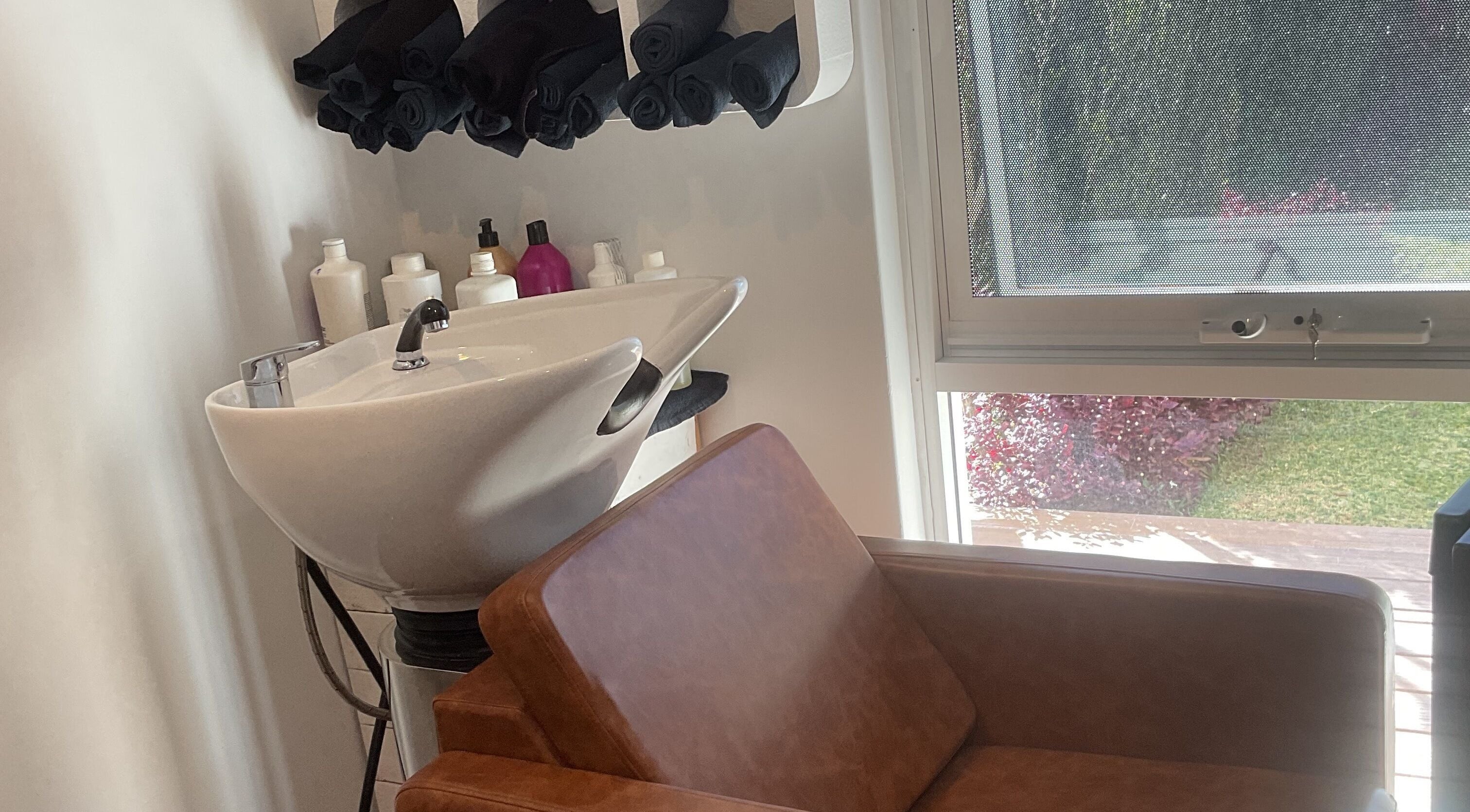 Chic salon wash station with brown chair at Blossom Hair Artistry, Quinns Rocks, Western Australia, AU.