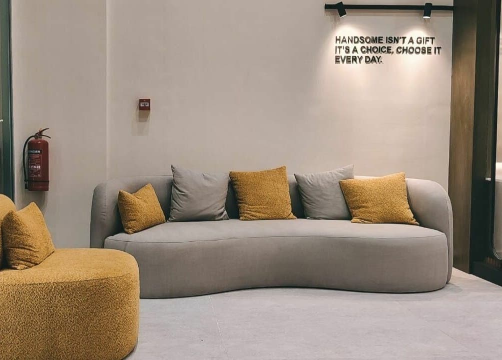Modern lounge at Handsome - هاندسم in Riyadh, Riyadh Province, SA with stylish grey and yellow seating.