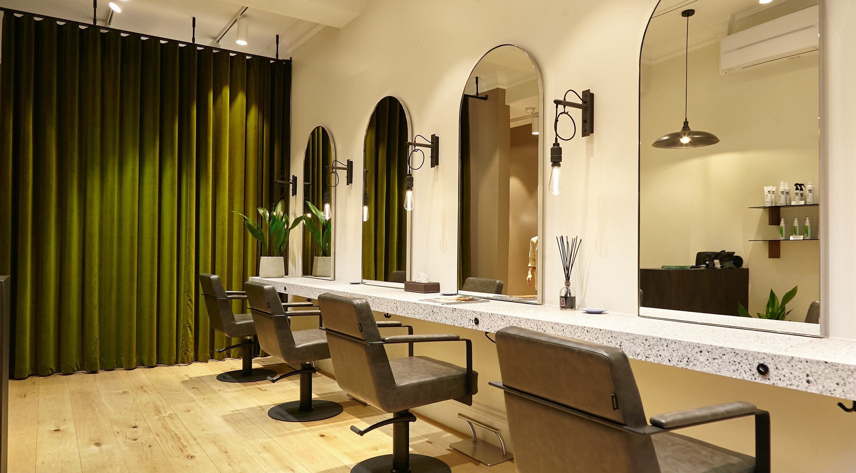 Elegant interior of Aube Hair in London, England, GB featuring stylish salon chairs and mirrors.
