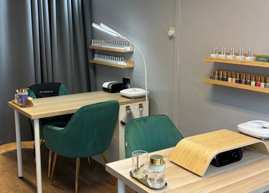 Modern nail salon interior at Beauty Mi, Sunbury-on-thames, England, GB, with stylish green chairs and nail polish racks.