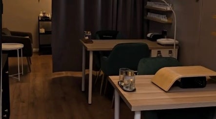 Cozy Beauty Mi treatment room with wooden tables in Sunbury-on-Thames, England, GB.