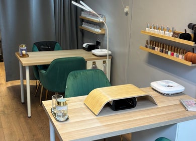 Nail station at Beauty Mi in Sunbury-on-thames, England, GB, featuring green chairs and neatly arranged nail products.