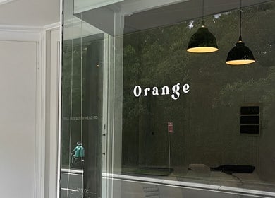 Exterior view of Orange Health Collective in North Bondi, New South Wales, AU with modern glass facade.