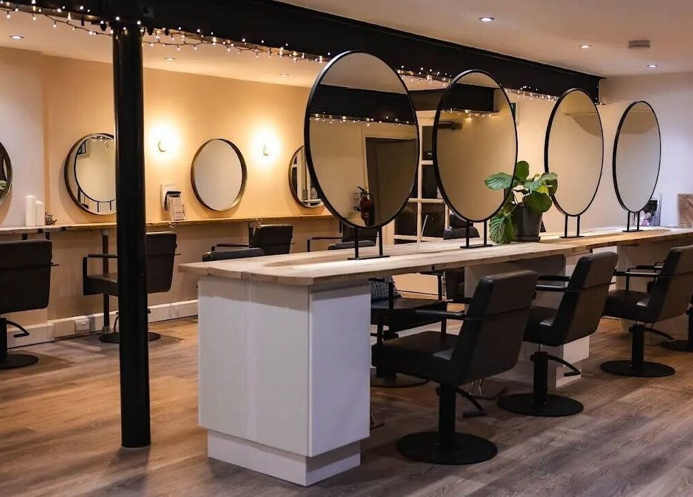 Modern salon interior at Skin Muse by Emma, Stratton Audley, England, GB, featuring stylish black chairs and mirrors.